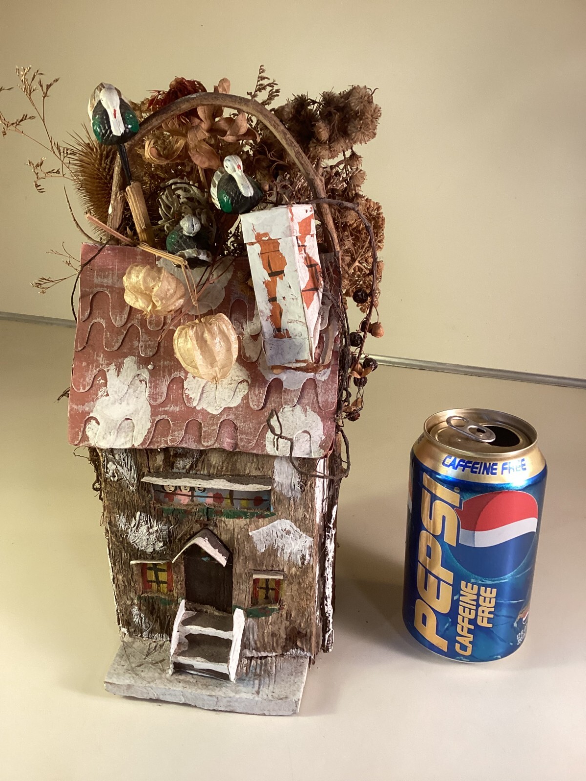 Wood birdhouse centerpiece with dried flowers, turkeys, twigs, windows, chimney
