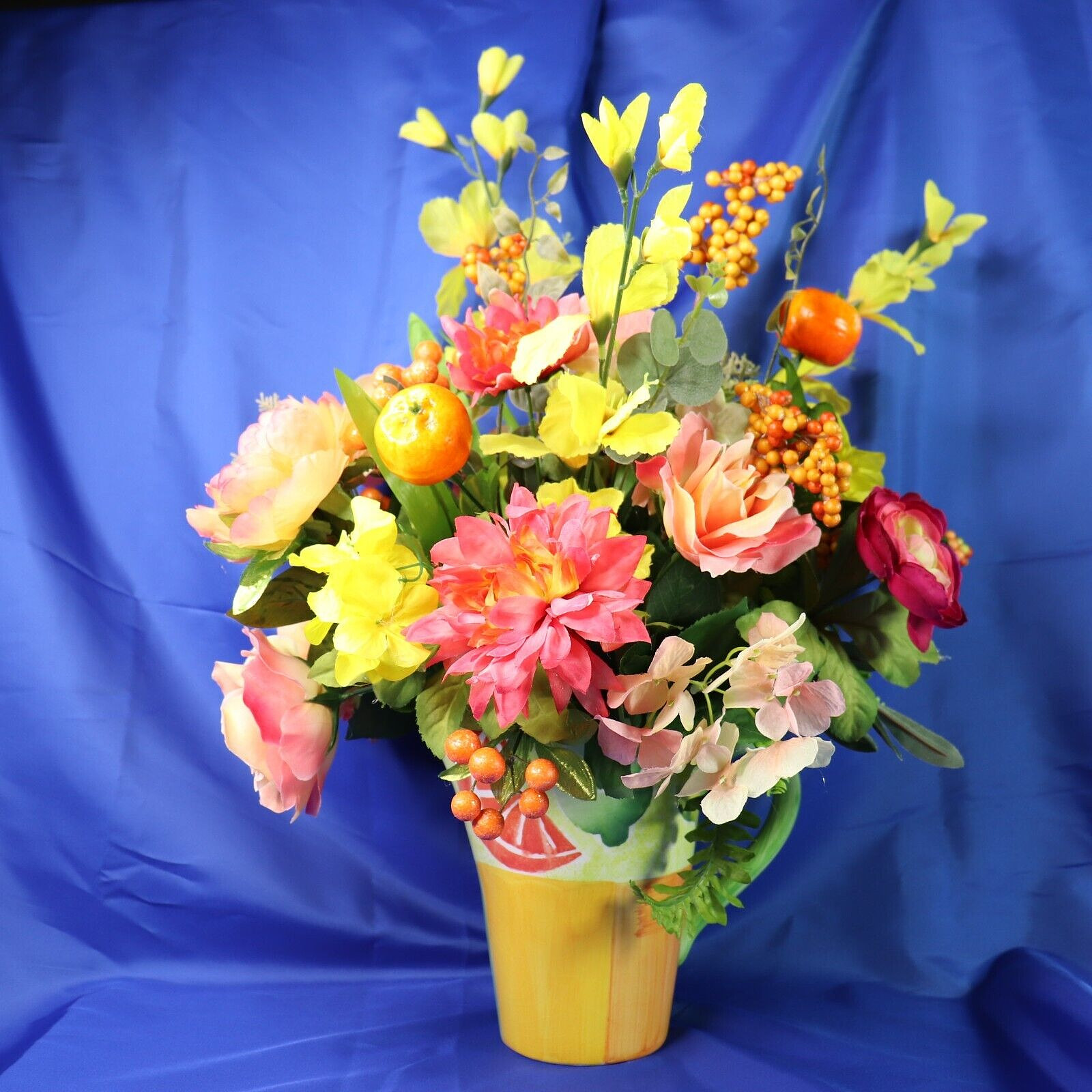 Very Colorful Floral Arrangement In A Beautiful Pitcher With Limes & Oranges