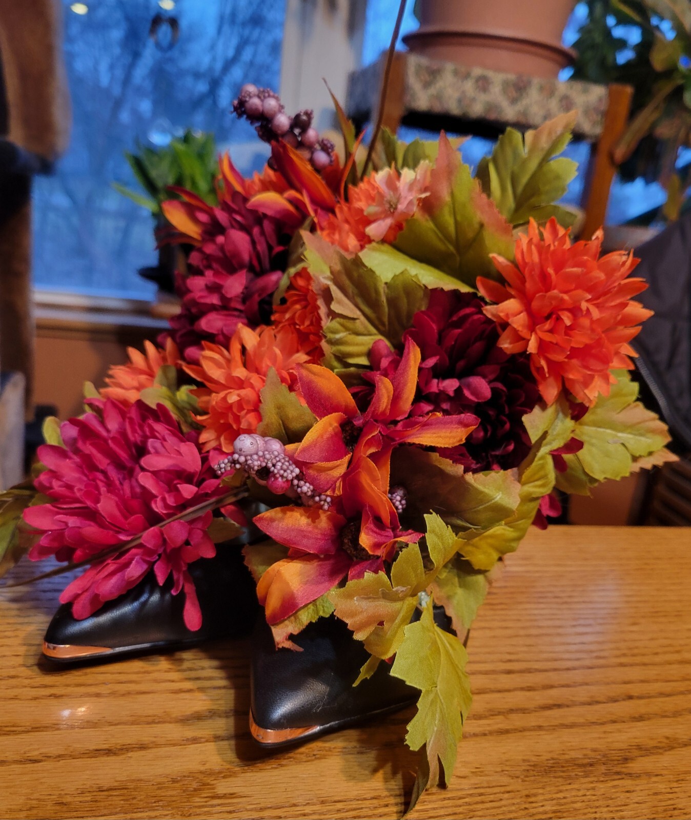 Floral Shoe Arrangement. Orange, Dark Red Flowers in Black Heels with Gold Trim.