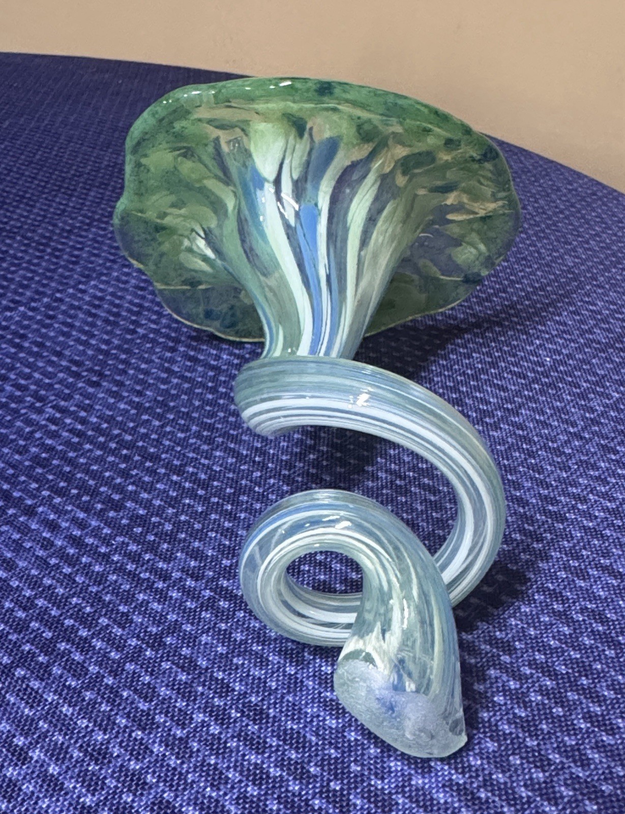 blown glass flower with a speckled green, blue, and white color, curly stem 7”