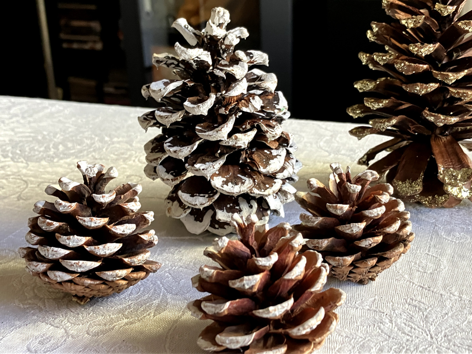 LOT OF 5 PINE CONES DECORATED IN WHITE AND GOLD IN VARIOUS SIZES FROM 2 IN-4.5IN