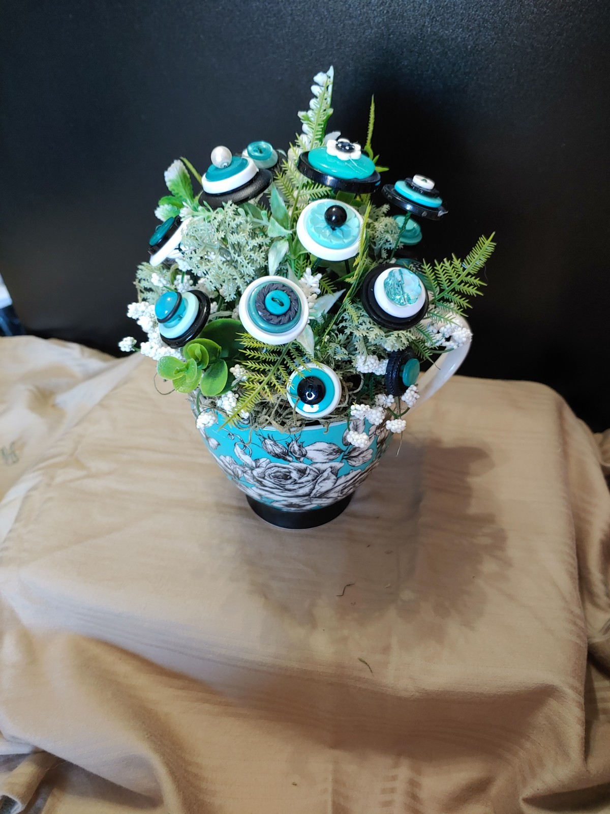 BUTTON BOUQUET IN matching turquoise, black, and white floral mug.