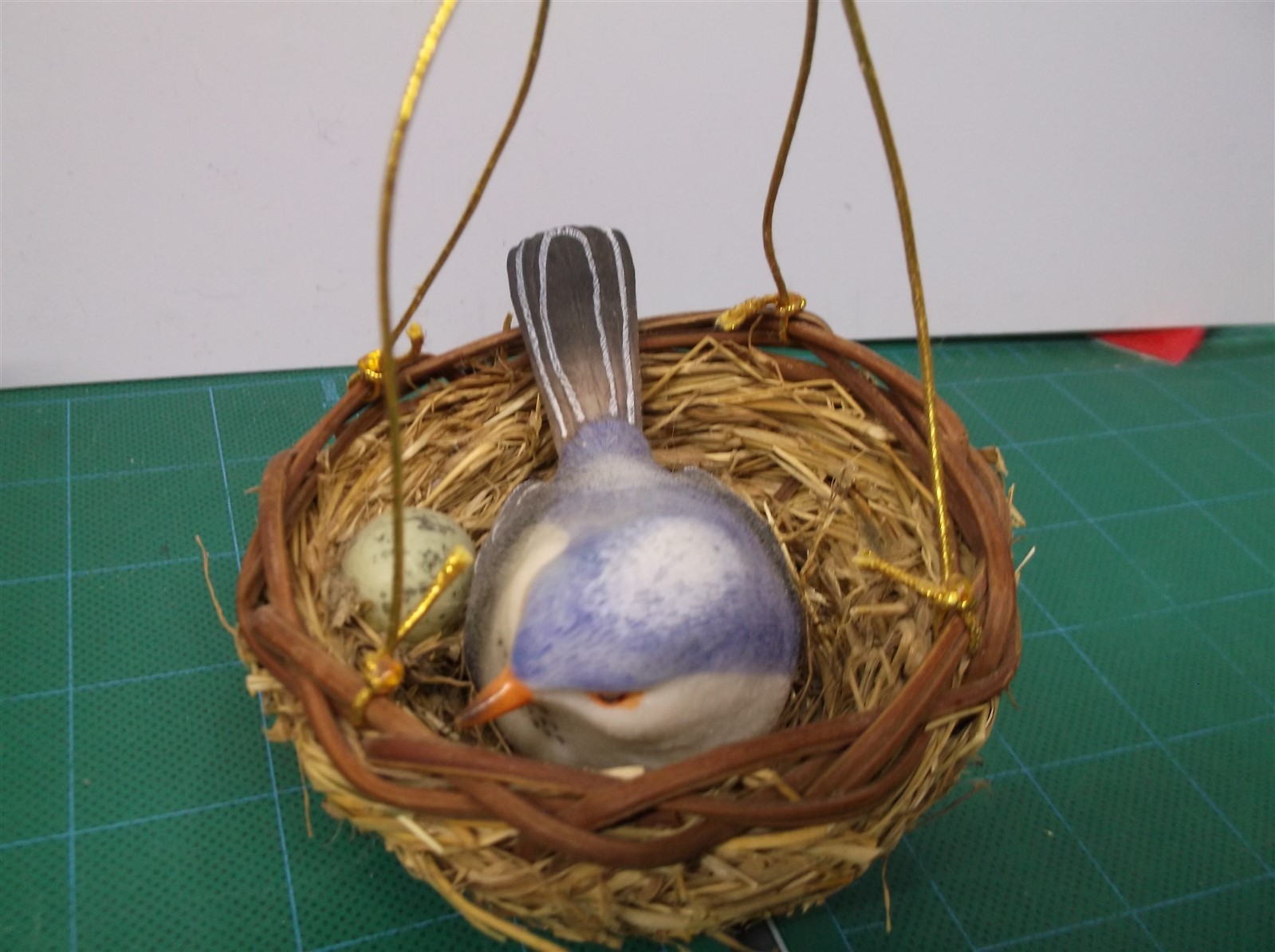 small fake blue bird and nest with green egg