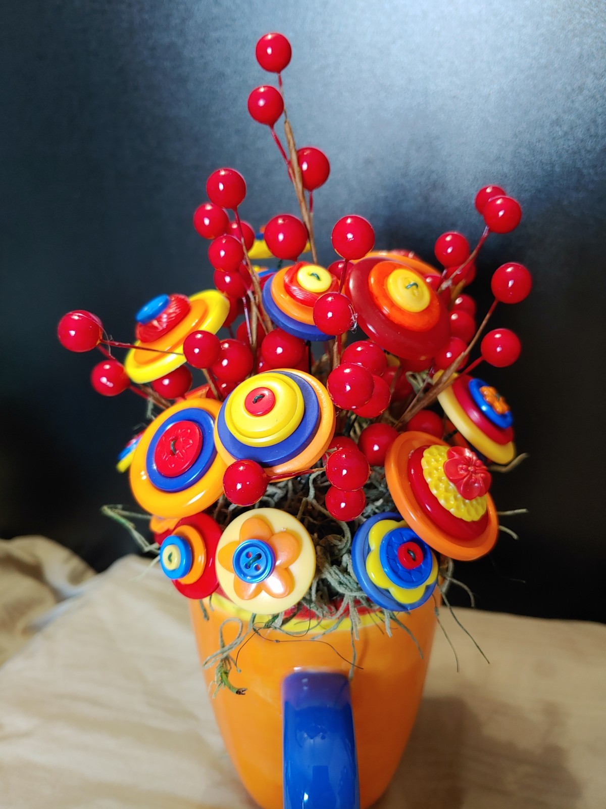 Bright Button Bouquet in Orange Coffee Mug. Red, orange, yellow. fun and playful