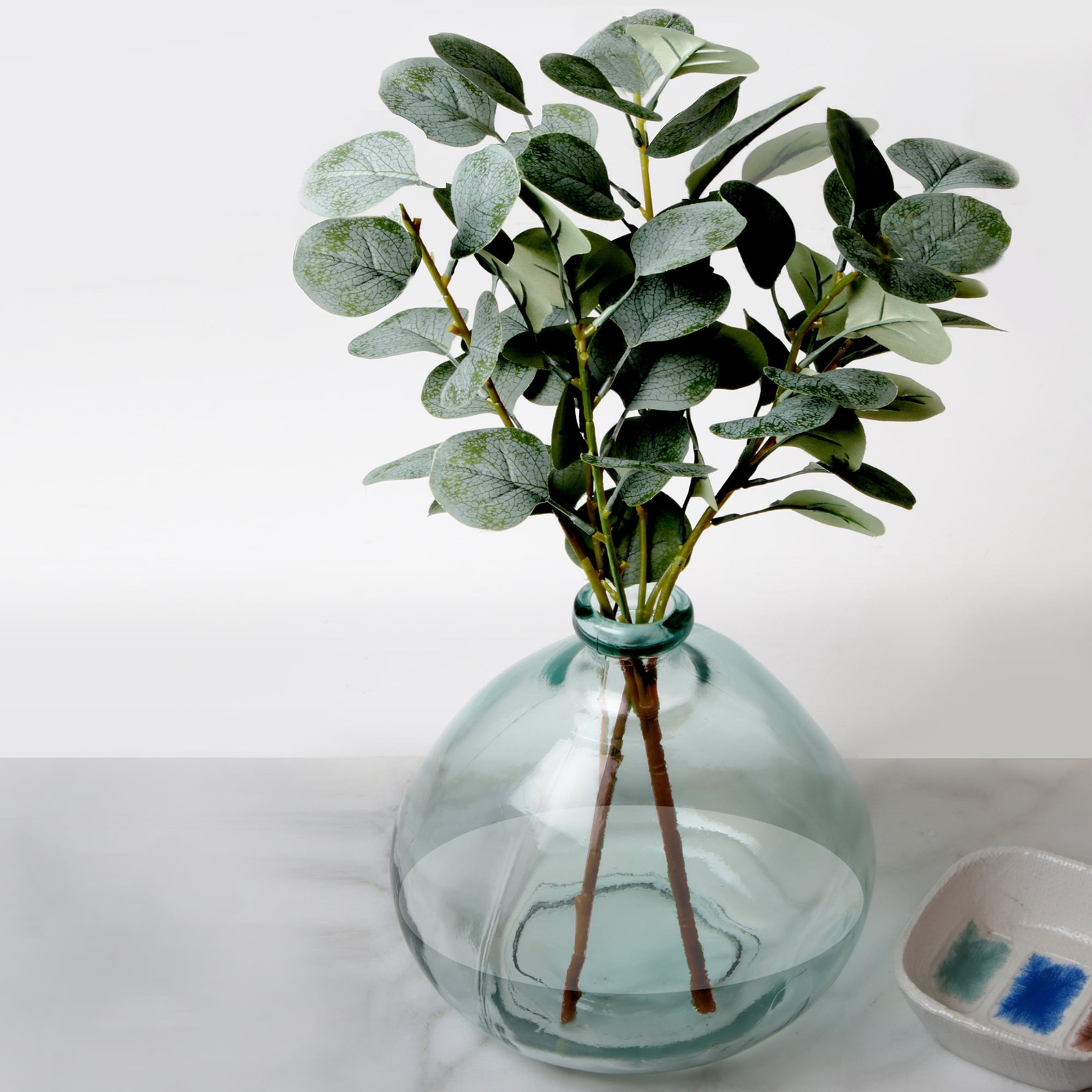 Artificial Green Eucalyptus Leaf Stems in Large Clear Blown Glass Vase