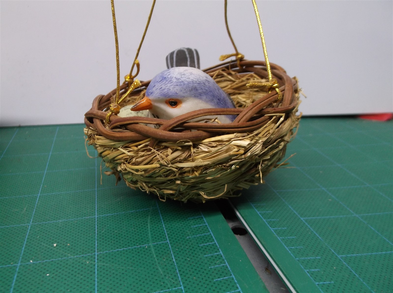 small fake blue bird and nest with green egg