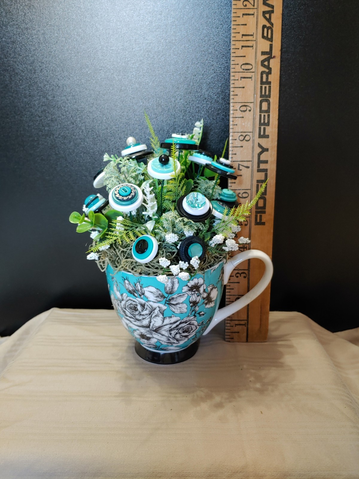 BUTTON BOUQUET IN matching turquoise, black, and white floral mug.
