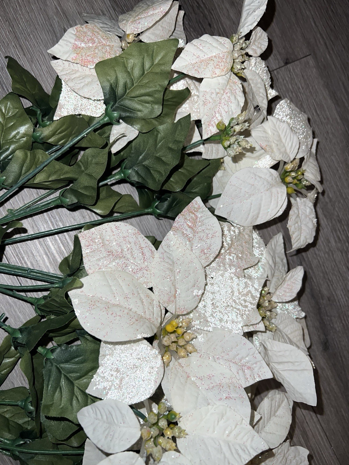 2 artificial white poinsettia bushes with green leaves and sparkle details
