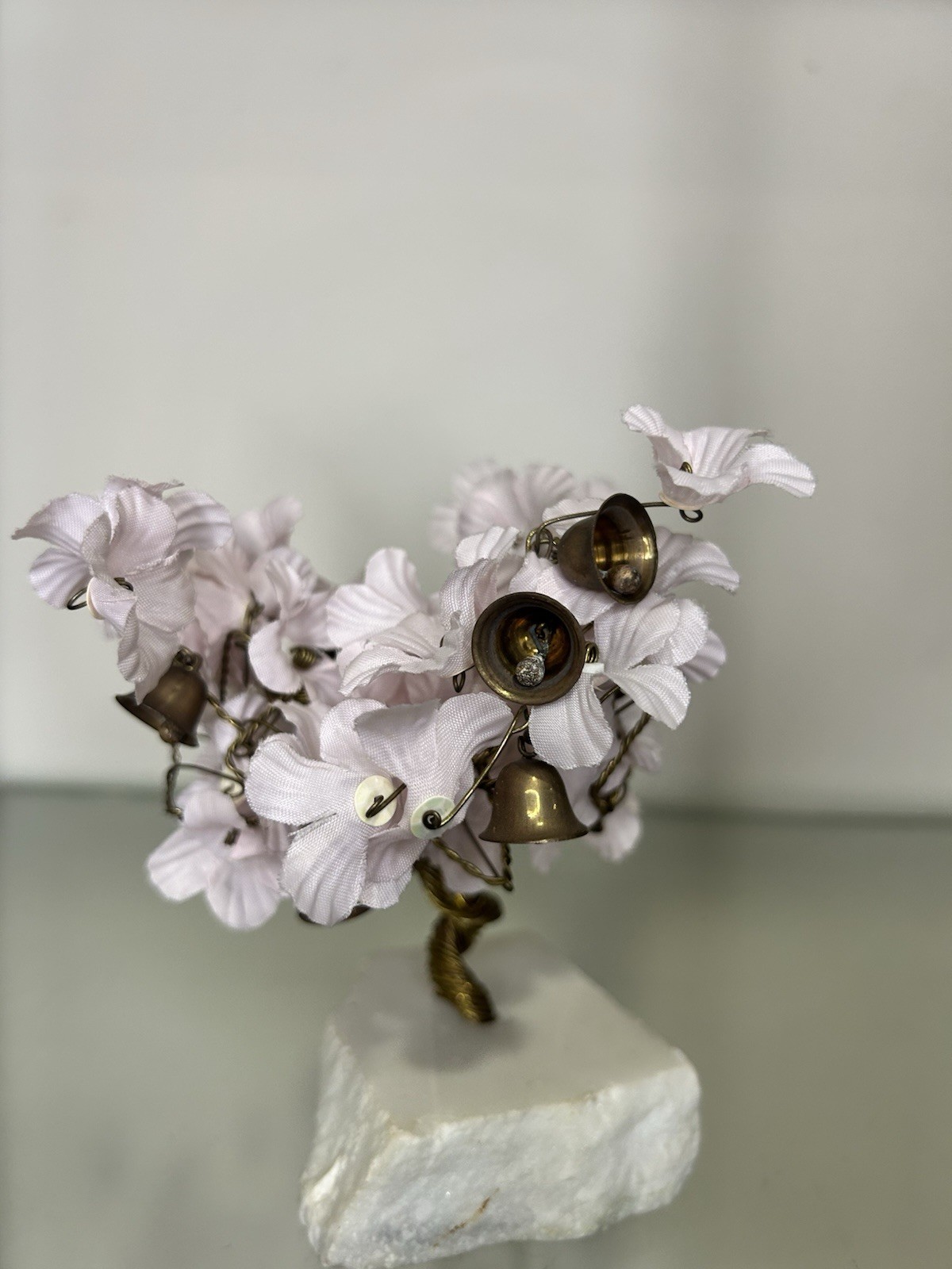 vintage wire prosperity tree with silk flowers and brass bells on a marble base