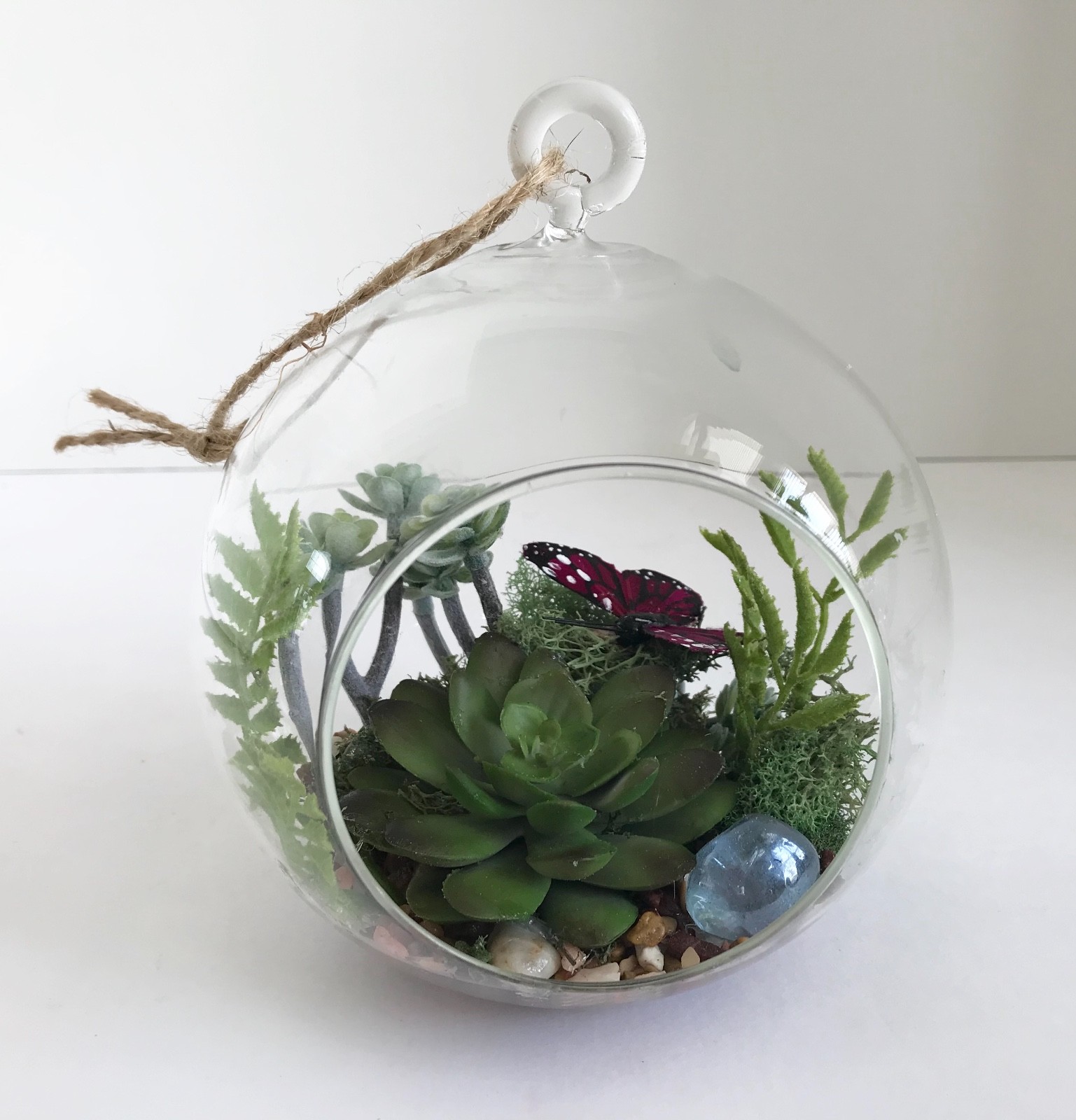 Hanging Round Glass Vase with Artificial Green Grass Succulents and a Purple But