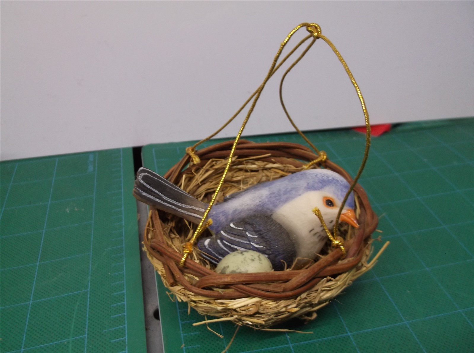 small fake blue bird and nest with green egg