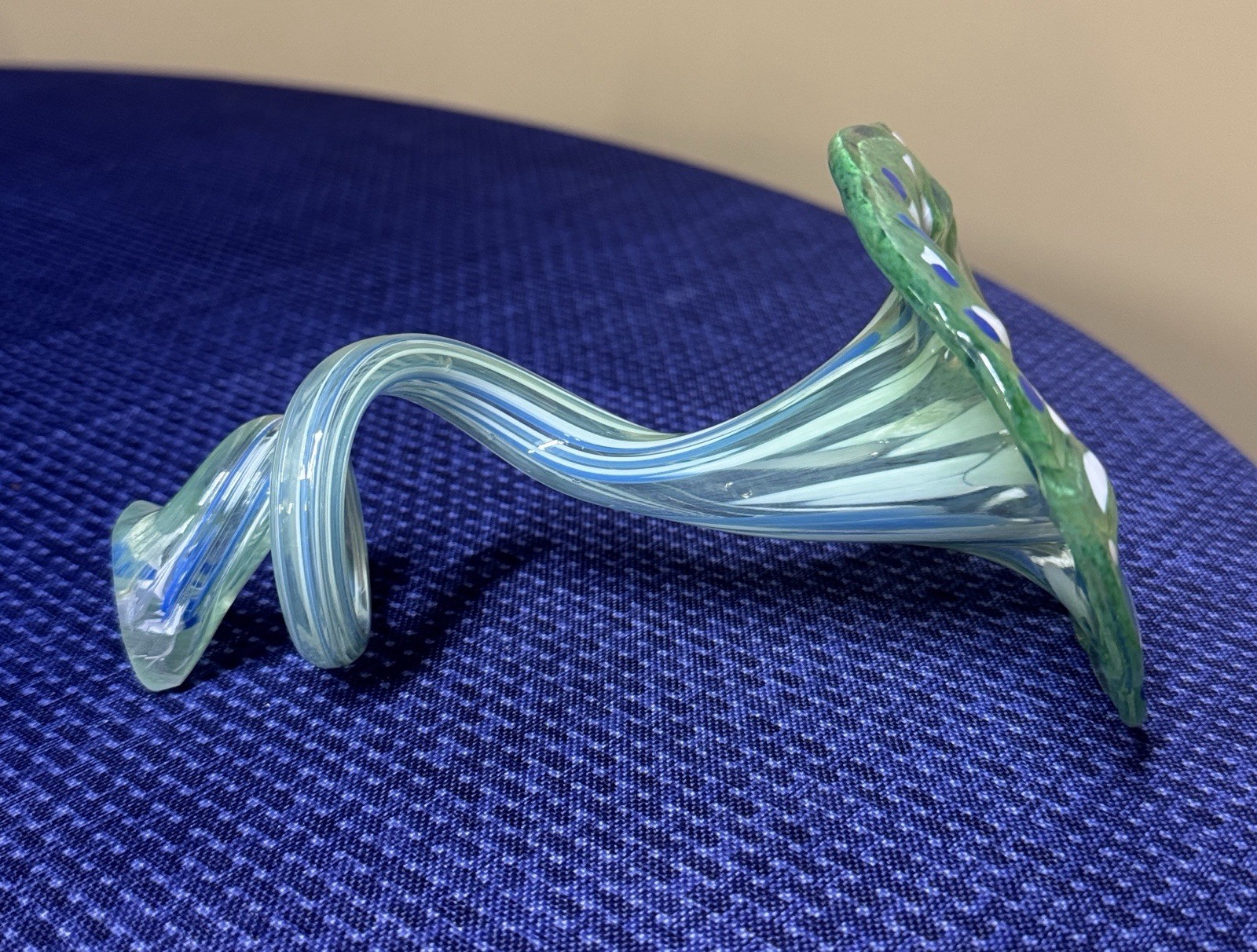 blown glass flower with a speckled green, blue, and white color, curly stem 7”
