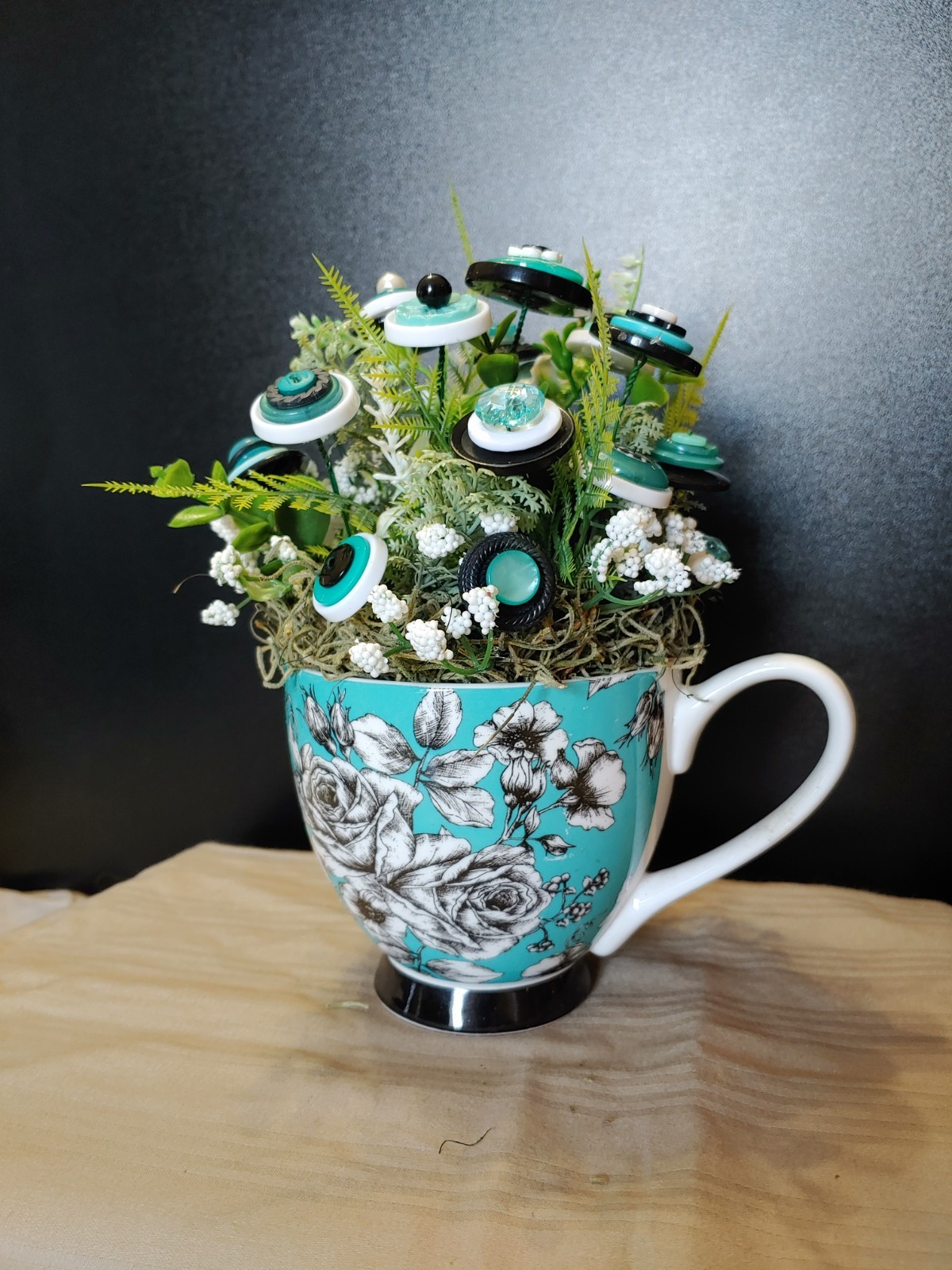 BUTTON BOUQUET IN matching turquoise, black, and white floral mug.