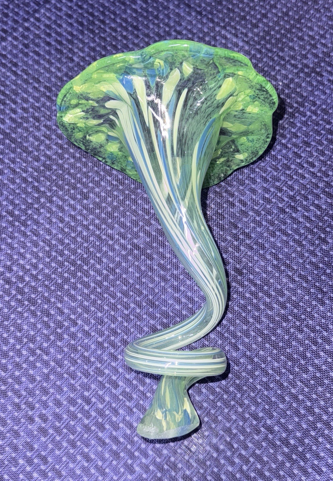 blown glass flower with a speckled green, blue, and white color, curly stem 7”