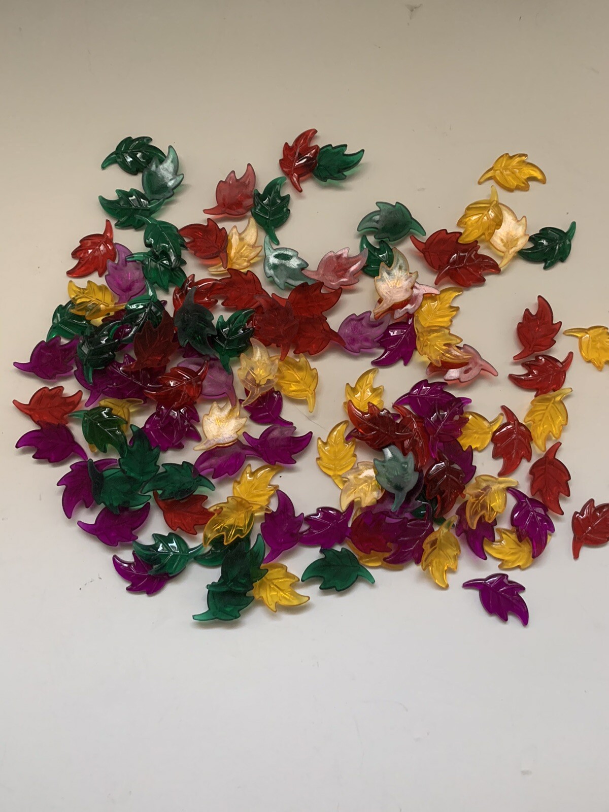 Bag of plastic leaves to scatter for Autumn decoration. Green,red,gold & violet 