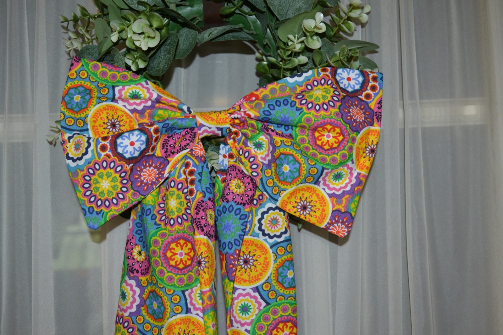 Wreath sash with bow in a colorful kalidescope pattern