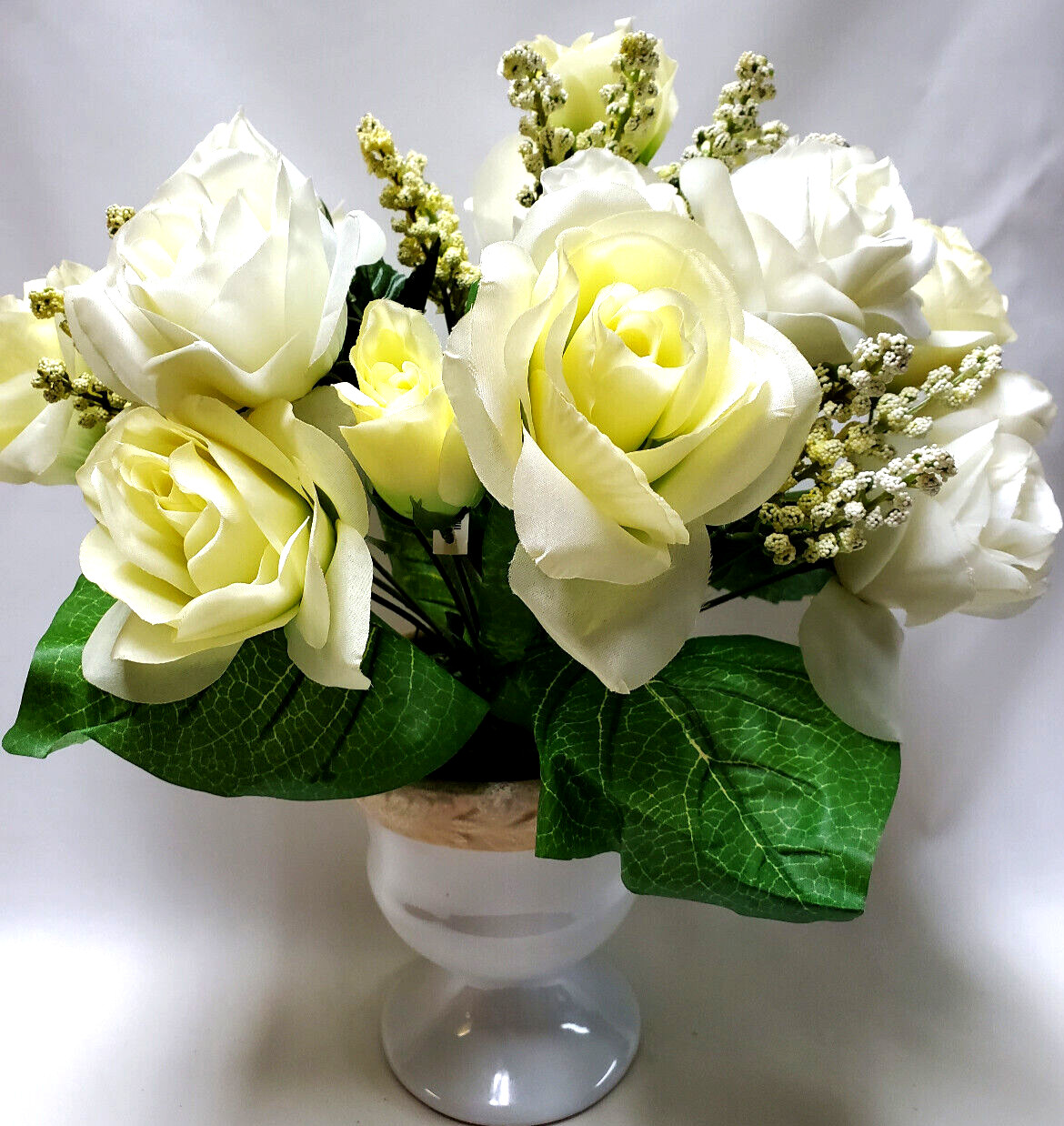 White and pale-yellow silk roses arrangement centerpiece in white vase