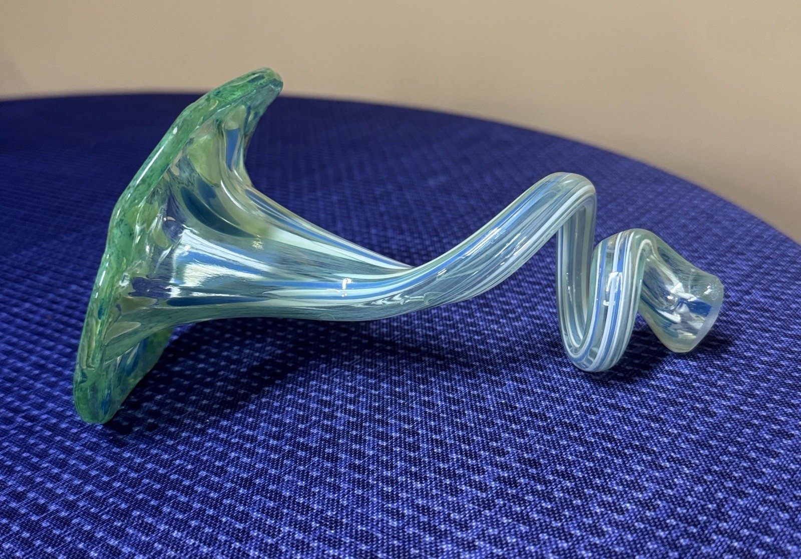 blown glass flower with a speckled green, blue, and white color, curly stem 7”