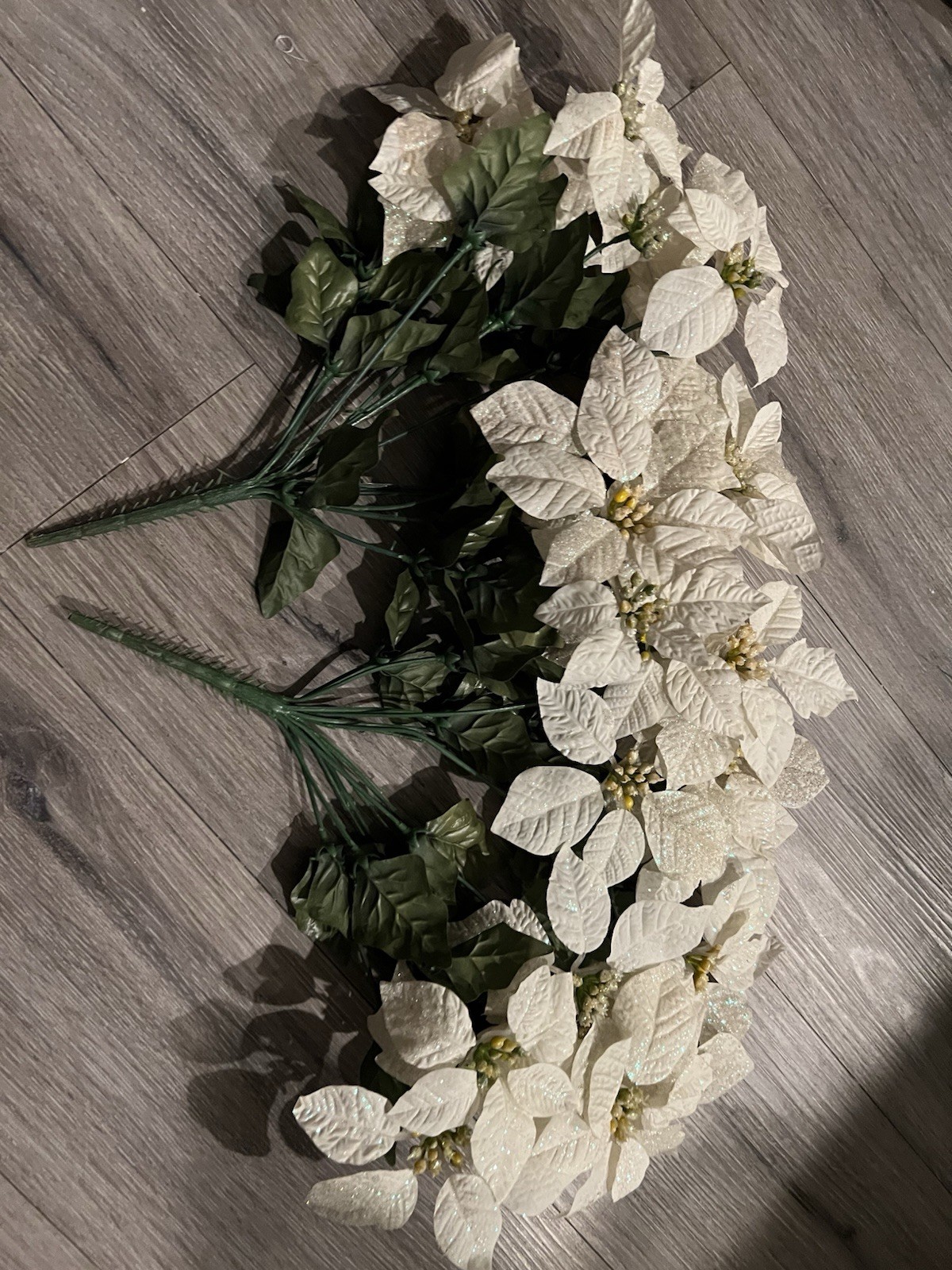 2 artificial white poinsettia bushes with green leaves and sparkle details