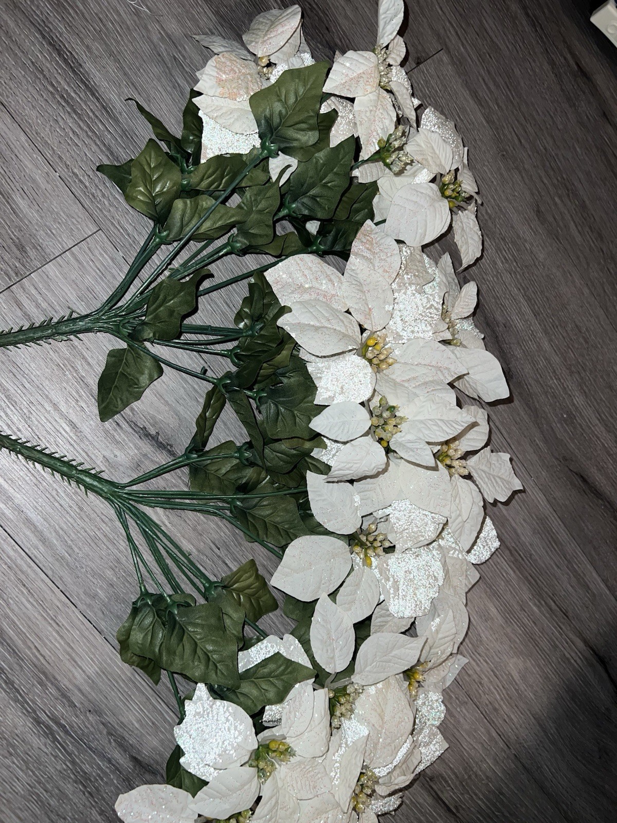 2 artificial white poinsettia bushes with green leaves and sparkle details