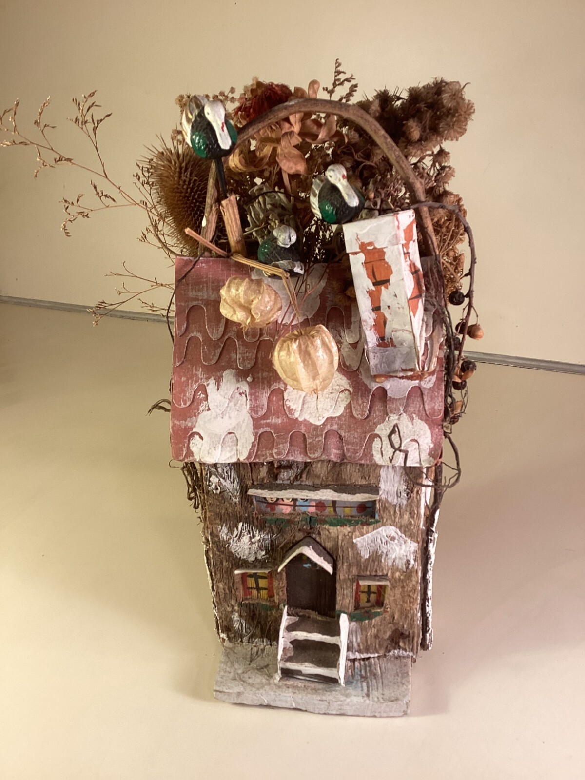 Wood birdhouse centerpiece with dried flowers, turkeys, twigs, windows, chimney