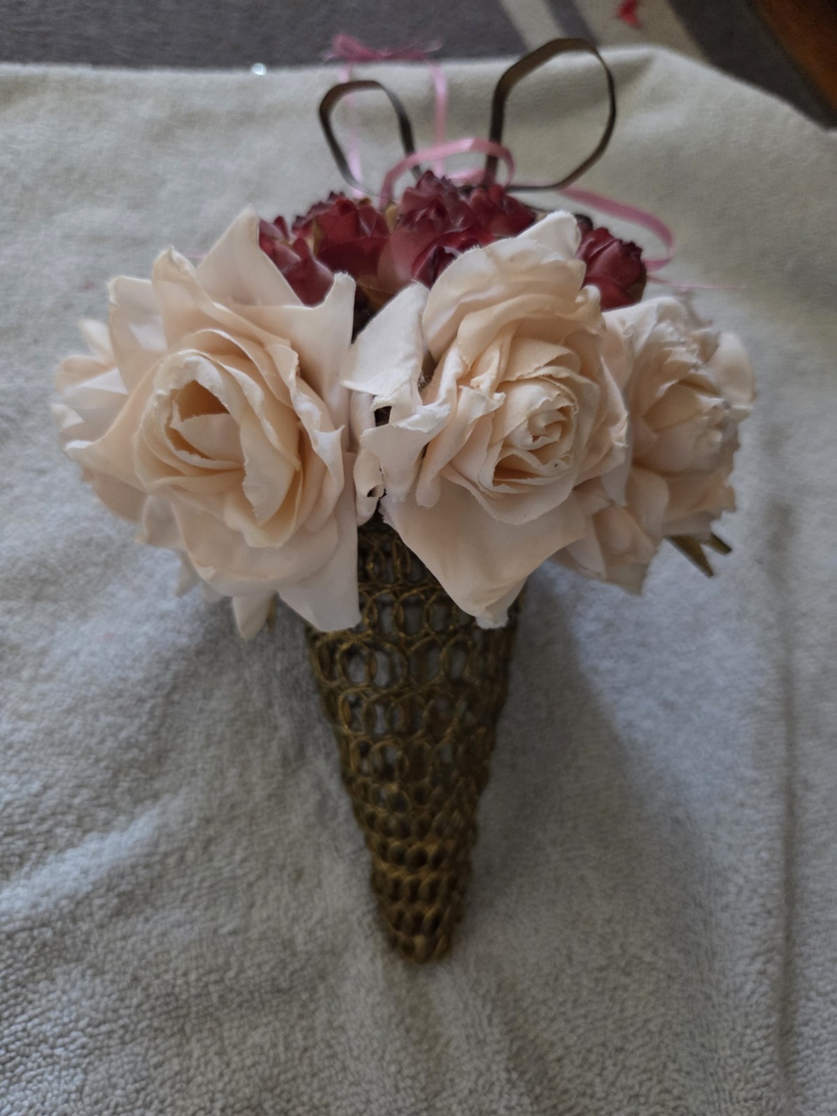 decorative artificial flower arrangement featuring cream and maroon roses