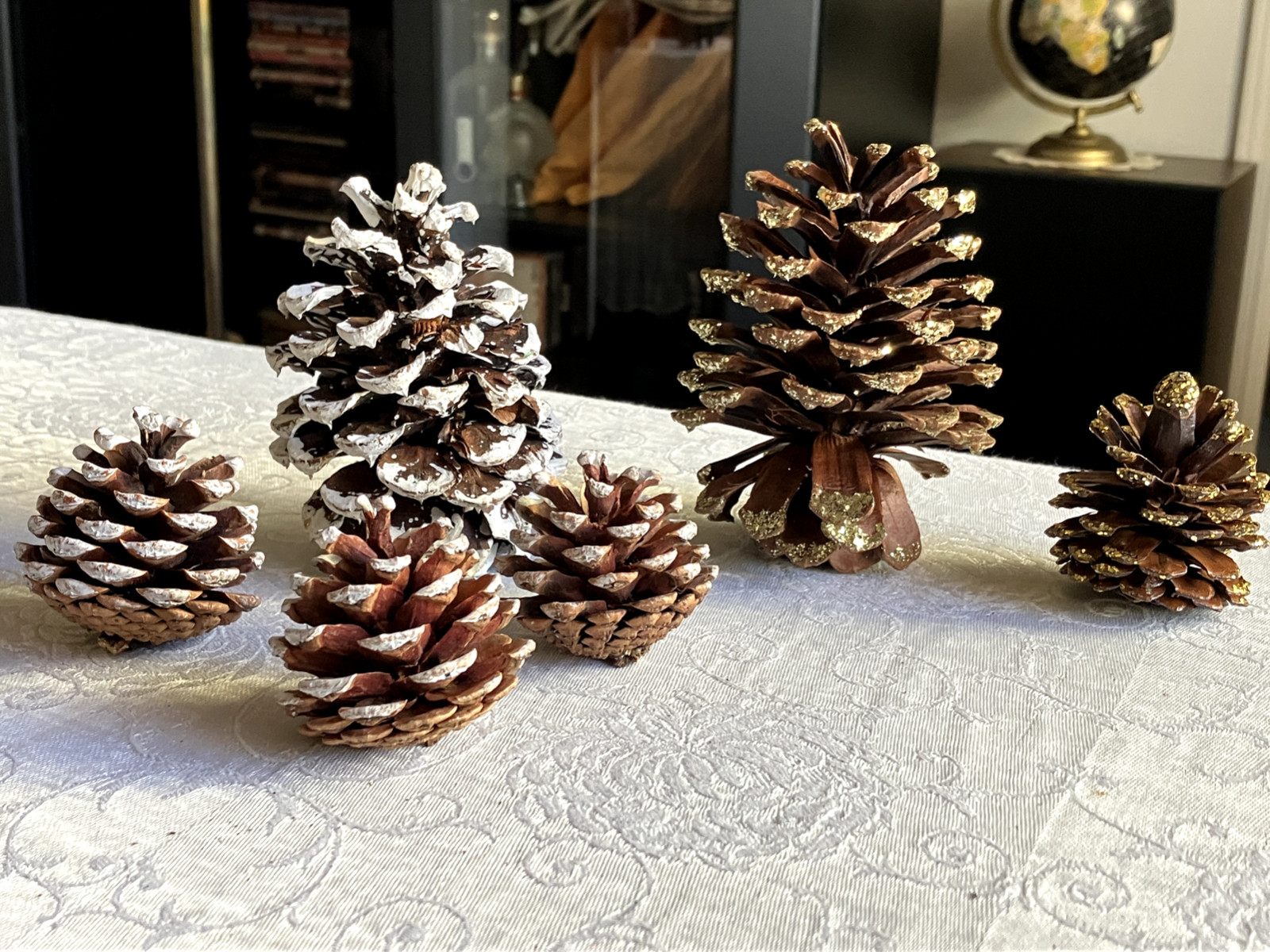 LOT OF 5 PINE CONES DECORATED IN WHITE AND GOLD IN VARIOUS SIZES FROM 2 IN-4.5IN