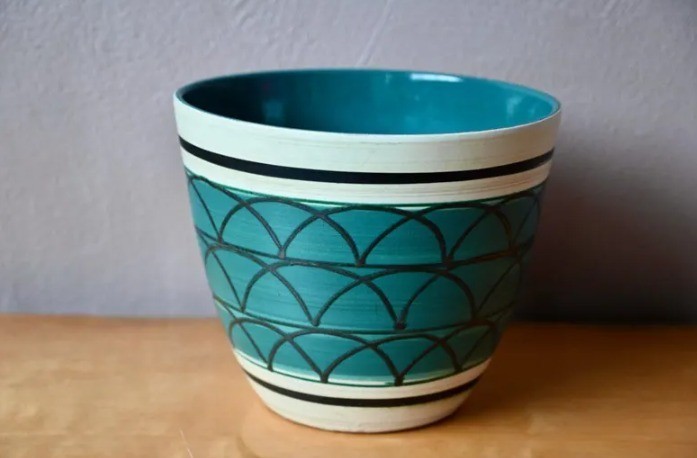 vintage ceramic flowerpot in green with geometric patterns in a boho