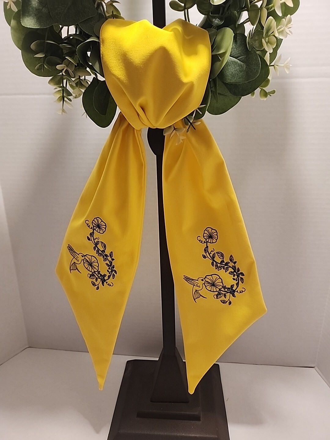 Wreath Sash In This Bright Yellow Color Emboidered With A Humming Bird In Navy