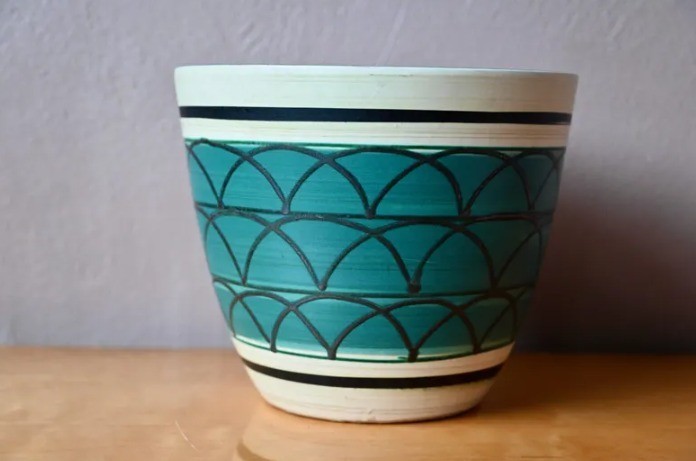 vintage ceramic flowerpot in green with geometric patterns in a boho
