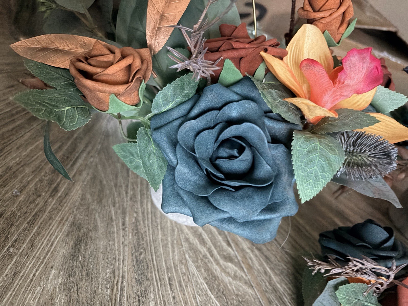 Teal & burnt orange centerpieces, bridal bouquet, and boutonnière. Lings flowers