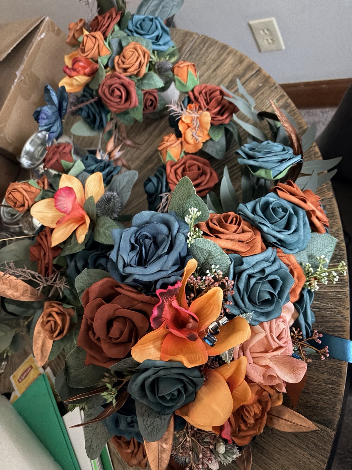 Teal & burnt orange centerpieces, bridal bouquet, and boutonnière. Lings flowers
