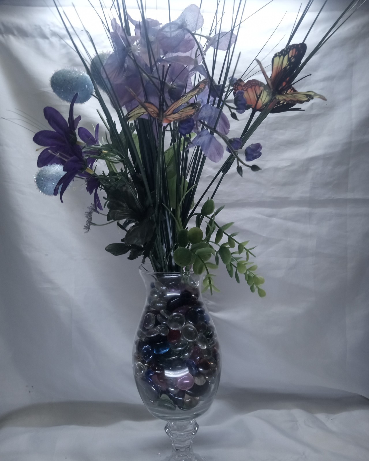 Faux Floral Arrangement with Butterflies in Glass Vase and decorative stones