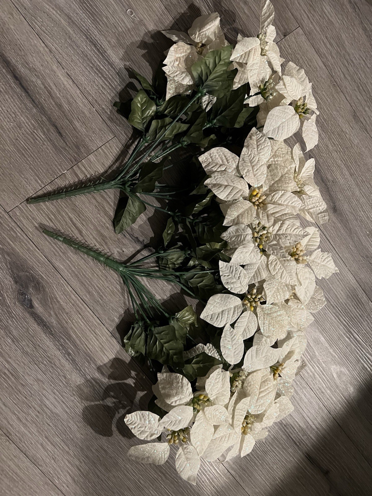 2 artificial white poinsettia bushes with green leaves and sparkle details