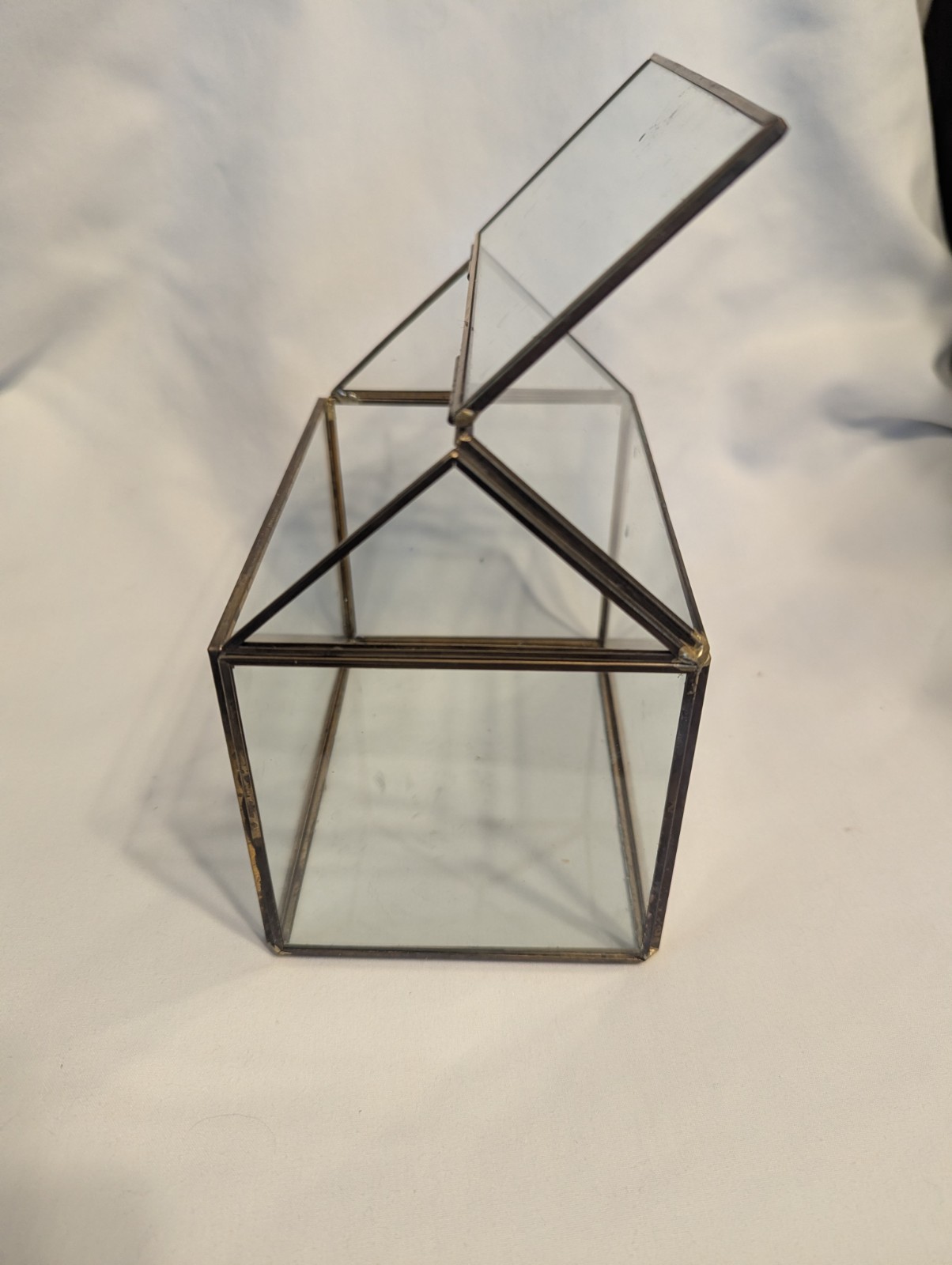Small house shaped metal and glass terrarium
