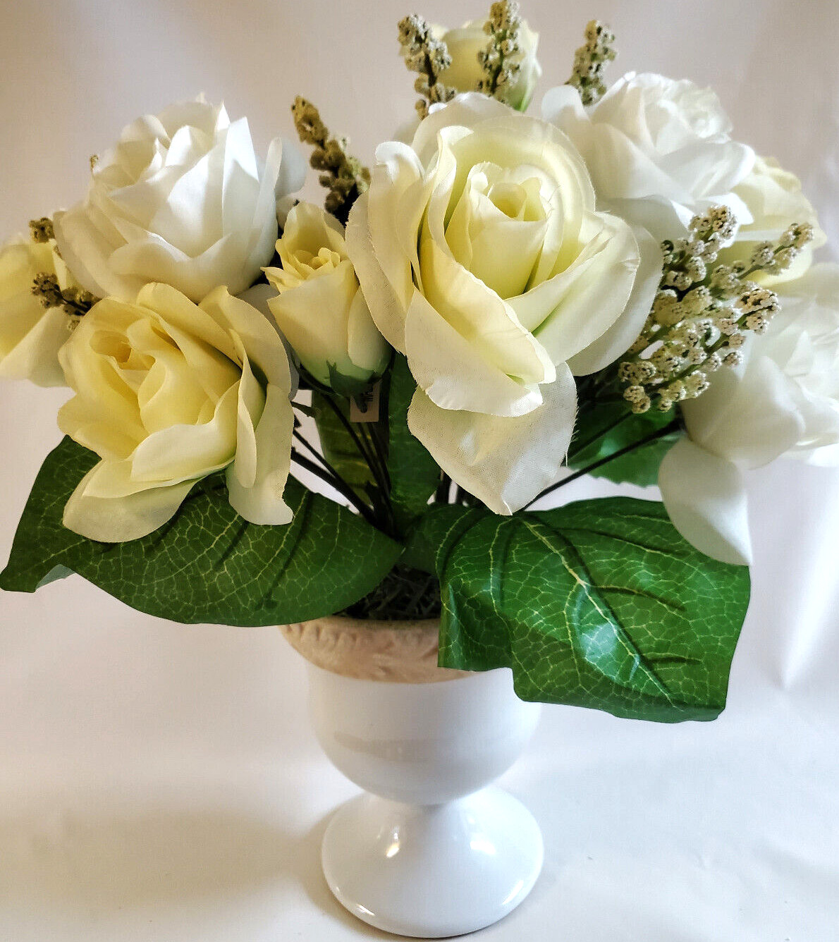White and pale-yellow silk roses arrangement centerpiece in white vase