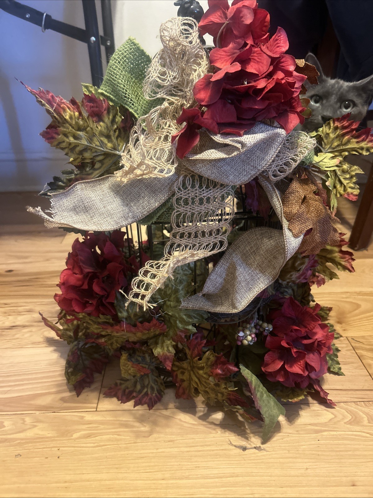 floral arrangement a mix of artificial flowers foliage around a Small Birdcage