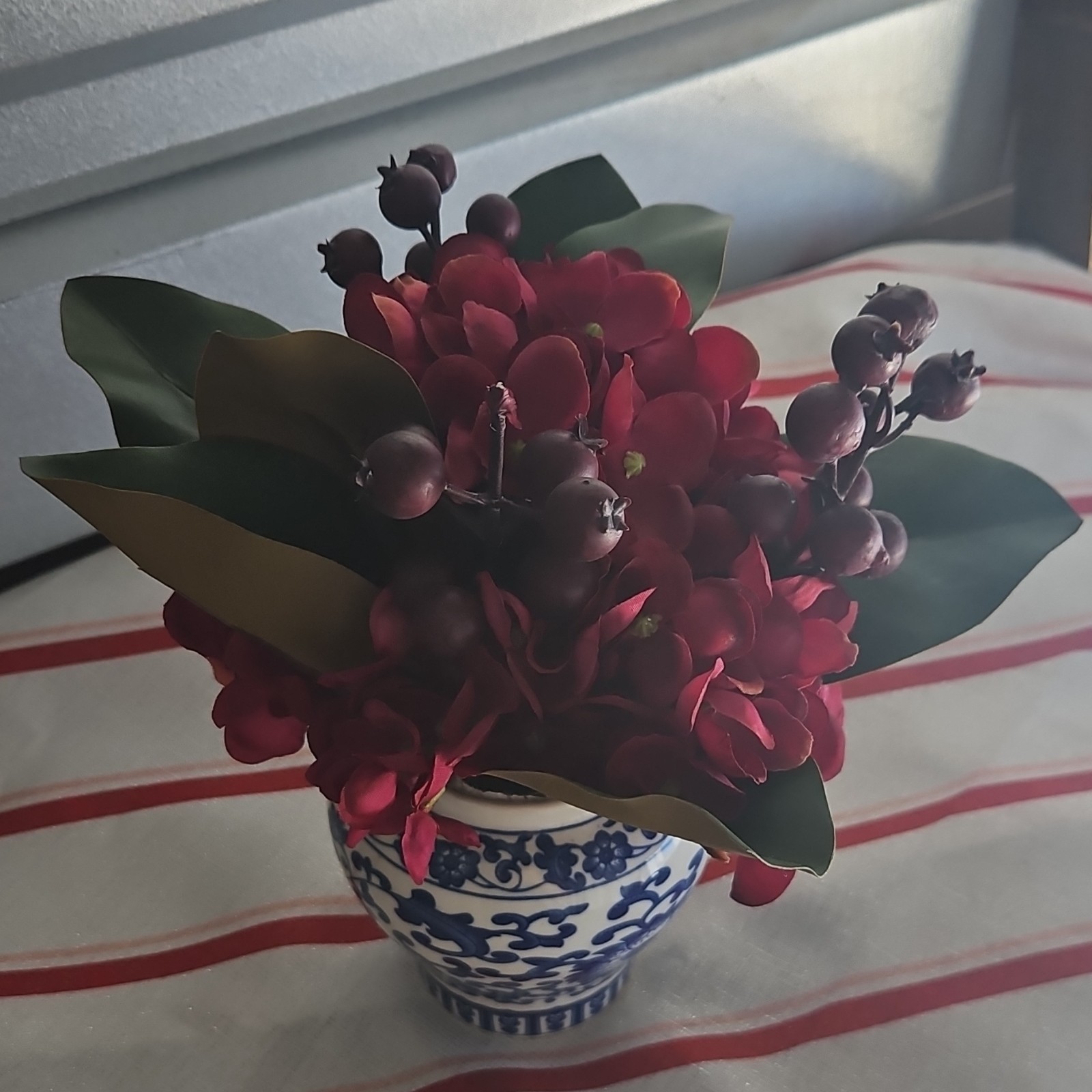 Artificial Red and Green Flower Arrangement Centerpiece in Blue and White Vase