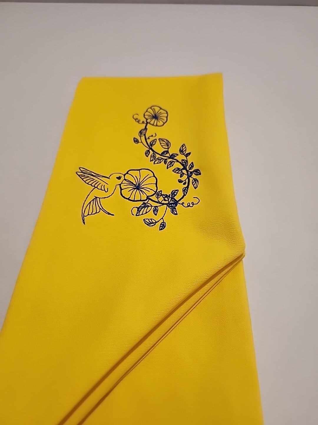 Wreath Sash In This Bright Yellow Color Emboidered With A Humming Bird In Navy