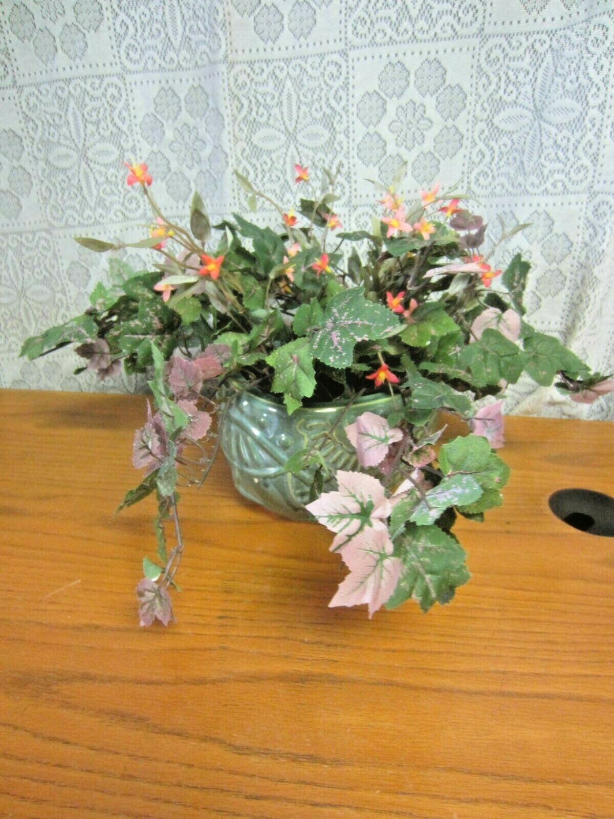 Green Elephant Planter With Green Foliage and Small Orange Flowers