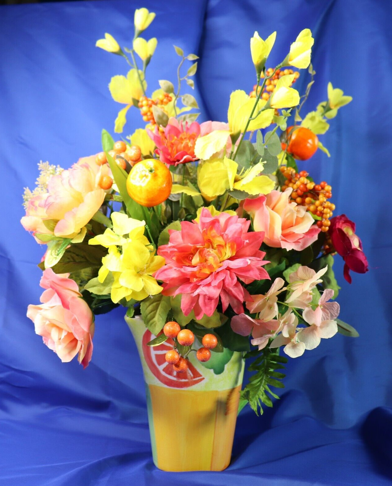 Very Colorful Floral Arrangement In A Beautiful Pitcher With Limes & Oranges