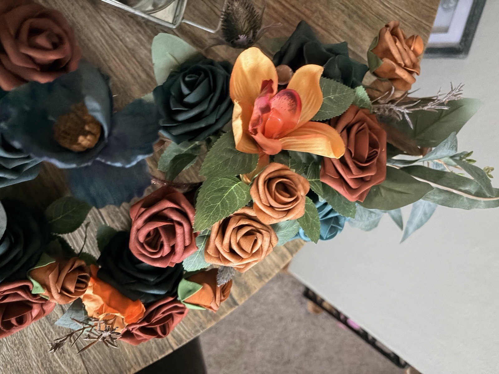 Teal & burnt orange centerpieces, bridal bouquet, and boutonnière. Lings flowers