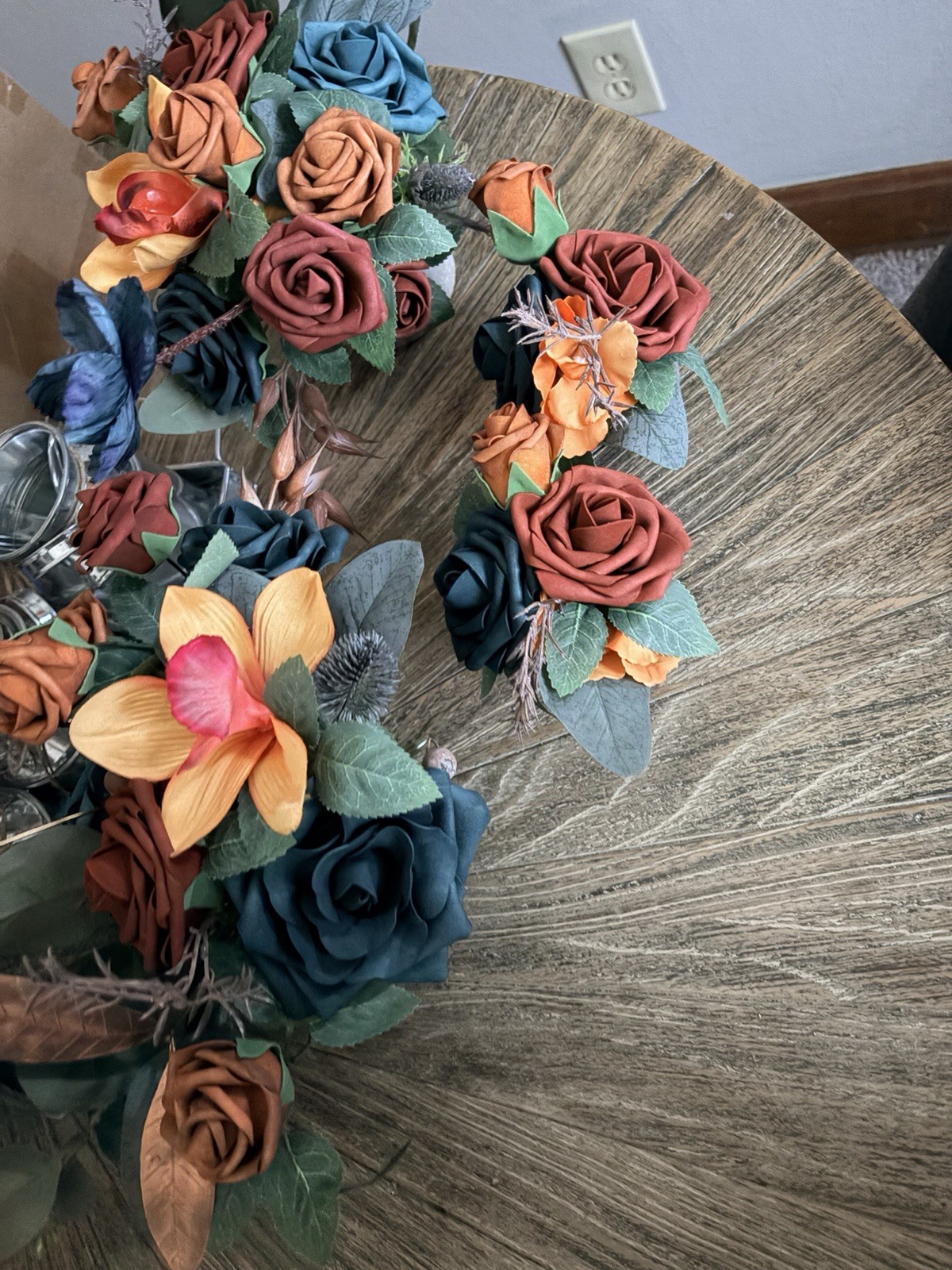 Teal & burnt orange centerpieces, bridal bouquet, and boutonnière. Lings flowers