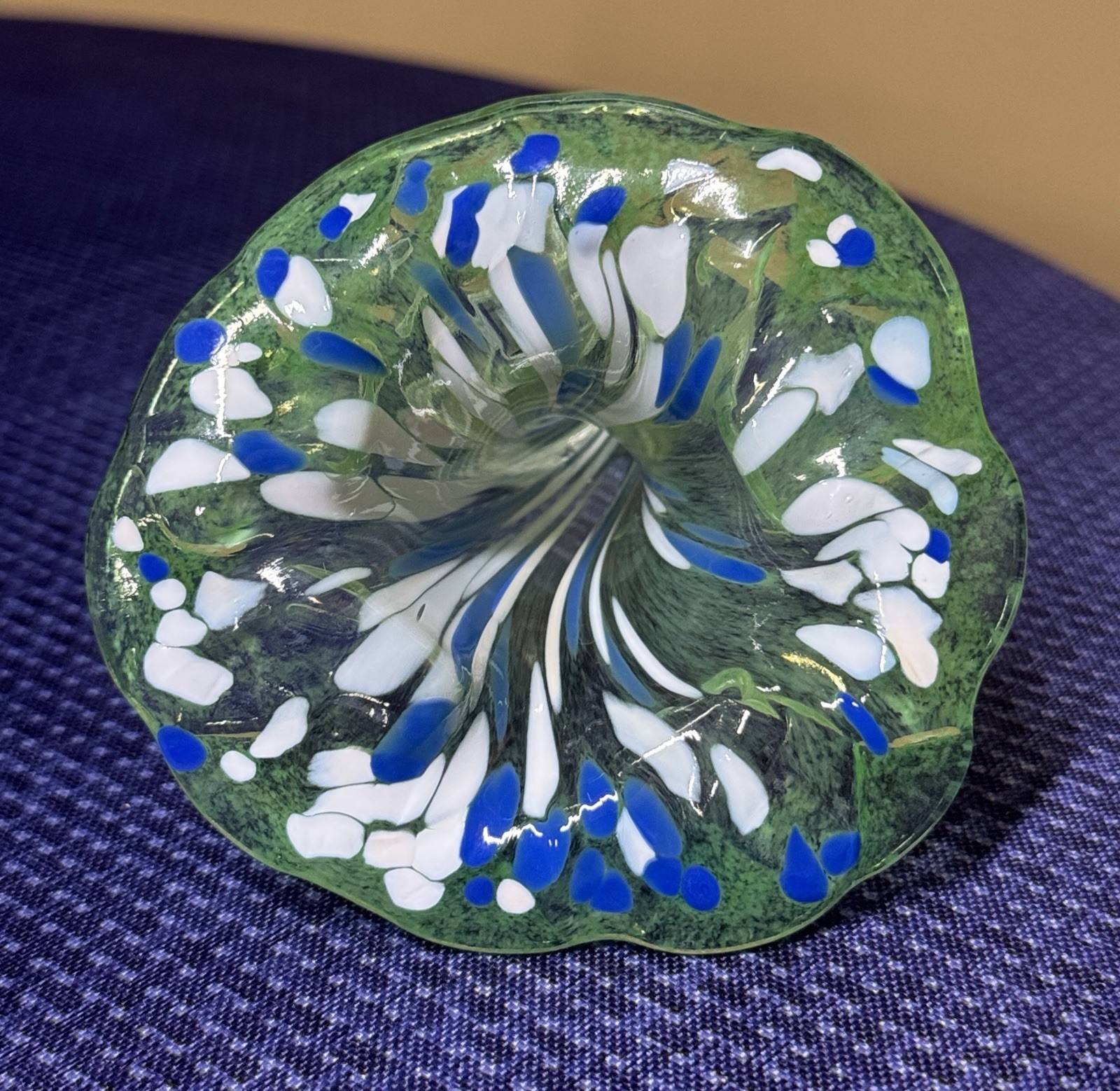 blown glass flower with a speckled green, blue, and white color, curly stem 7”