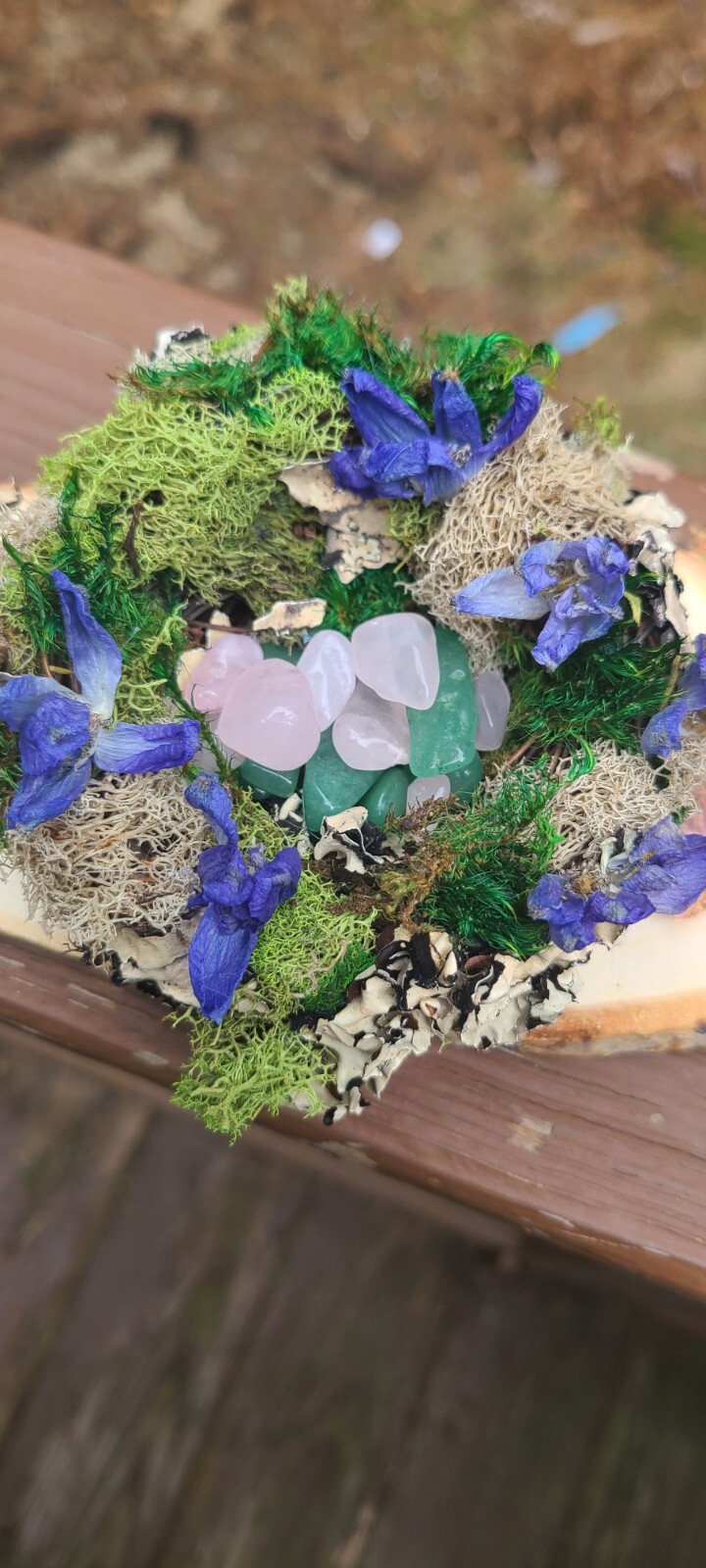 Spring Decor. Bird Nest With Moss Dried Flowers And Crystals. Resting On Wood.