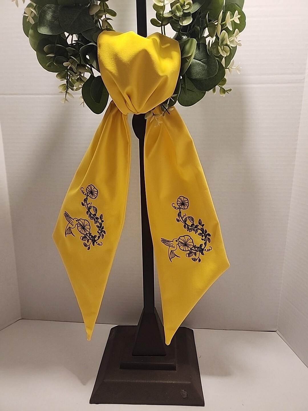 Wreath Sash In This Bright Yellow Color Emboidered With A Humming Bird In Navy
